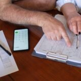 Extras de cont tipărit pe o masă, alături de un pix și o pereche de ochelari, pregătit pentru verificare