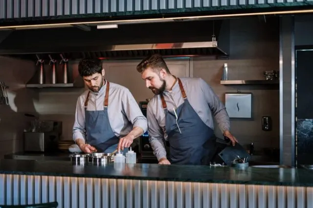 Bucătar care aranjează o farfurie caldă într-o bucătărie de restaurant
